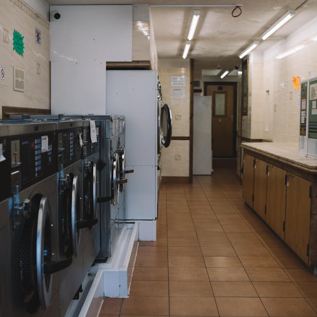 Empty laundry room with industrial washing machines and bright lighting, perfect for commercial use.